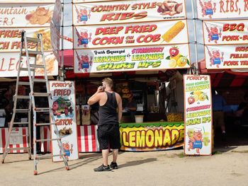 Rear view of man standing at store