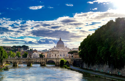 Arch bridge over river against buildings