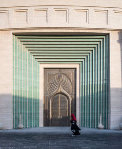 Woman walking by building in city