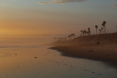 Scenic view of beach against sky during sunset