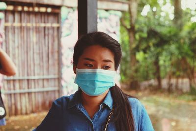 Close-up of woman wearing mask standing outdoors