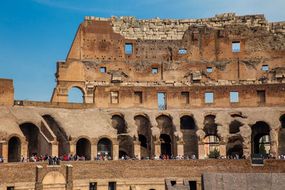 Tourists visiting the interior of the famous colosseum in rome