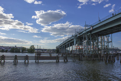 Pier over river against sky in city