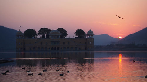 Sunrise and hawa mahal in silhouette in the middle of man sagar lake