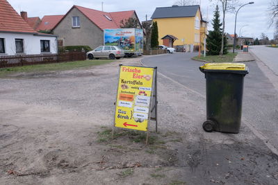 Road sign on street by buildings in city