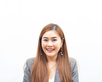 Portrait of smiling young woman against white background