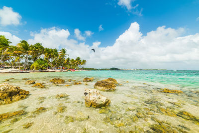 Scenic view of rocks on beach against sky