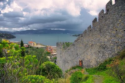 Scenic view of town by sea against sky