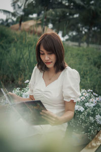 Portrait of young woman sitting on field