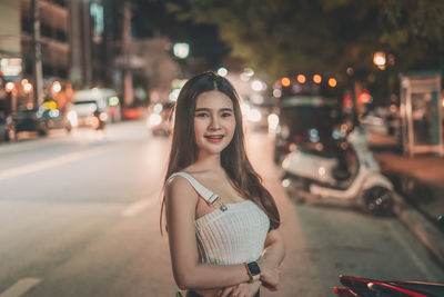 Portrait of smiling woman standing on street in city