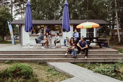 Family and friends spending leisure time while sitting at restaurant