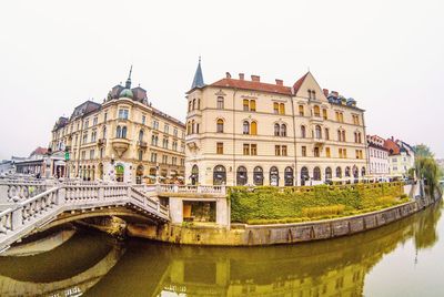 Arch bridge over river against buildings in city