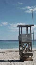 Chair on beach against sky