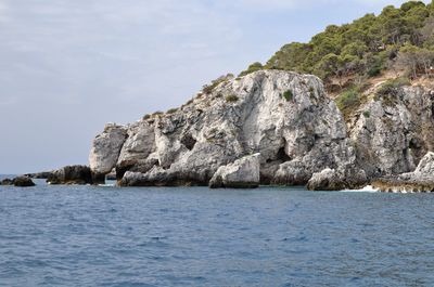 Rock formations in sea against sky