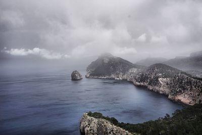 Scenic view of sea and mountains against sky