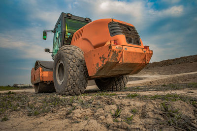 Low angle view of machinery on field against sky