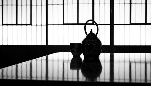 Silhouette of a japanese tea cup and tea kettle in a japanese house.