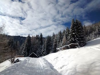 Scenic view of snow covered mountains against cloudy sky