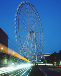 Ferris wheel in city against blue sky