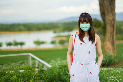 Portrait of woman standing against plants