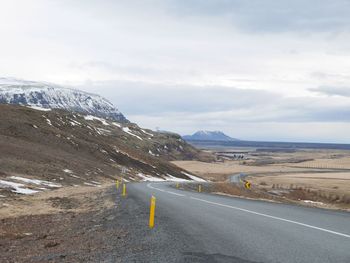 Road by mountain against sky
