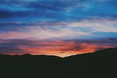 Silhouette of landscape against cloudy sky