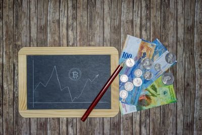 Directly above shot of slate with graph by currency on table