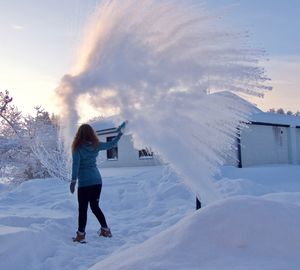 Rear view of woman standing on snow covered land