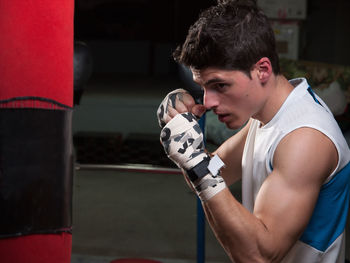 Man punching bag in boxing rink