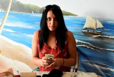 Portrait of young woman sitting on beach