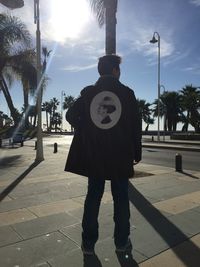 Low section of man standing on road