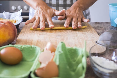 Midsection of man preparing food on cutting board in kitchen