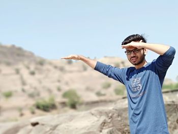 Portrait of man standing on mountain against sky