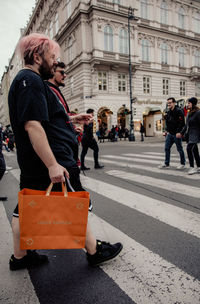 People walking on road along buildings