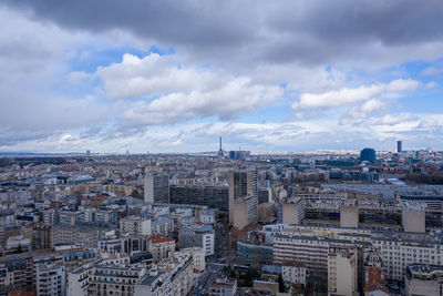 High angle view of city buildings against cloudy sky