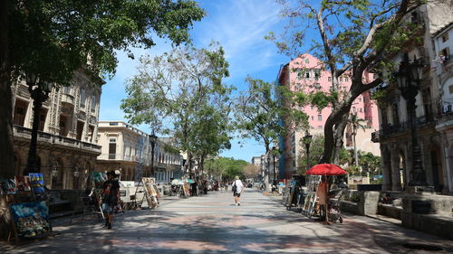 People walking on street amidst buildings in city