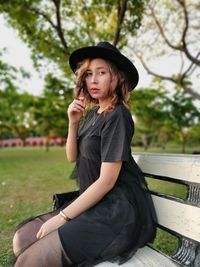 Portrait of young woman sitting in park