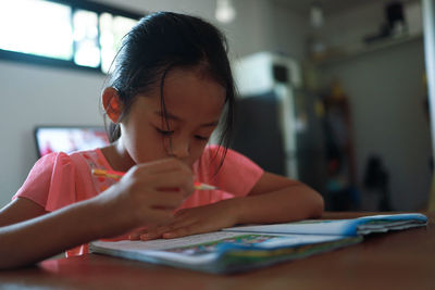 Close-up of girl with hands on table