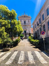 Street amidst buildings against blue sky