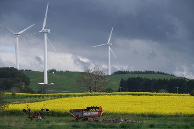 Windmills on field against sky