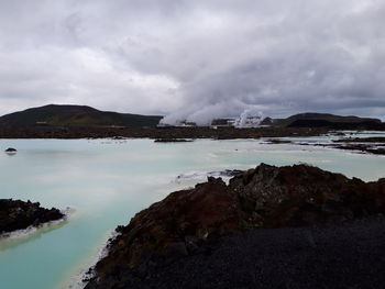 Scenic view of sea and mountains against sky