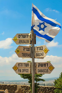 Flag and signs against sky