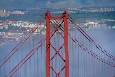 View of suspension bridge against cloudy sky. 25th april bridge, lisbon, portugal. 