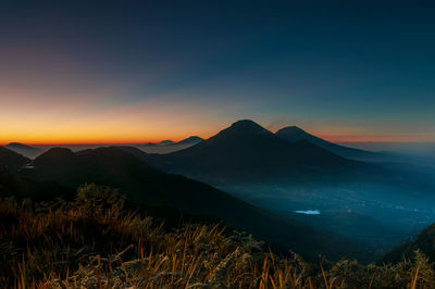 Scenic view of silhouette mountains against sky during sunset