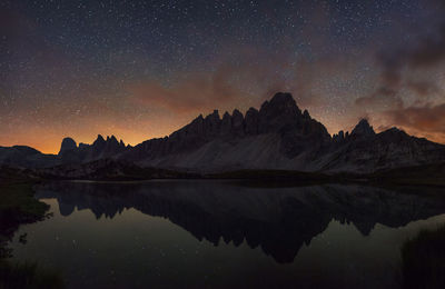 Scenic view of lake against sky at night