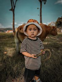 Portrait of boy standing on grassy field