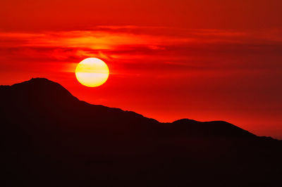 Scenic view of mountains against orange sky