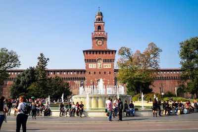 Group of people in front of building against sky