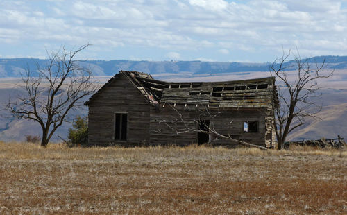 House on field against cloudy sky