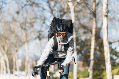 Mature delivery male riding bicycle on sunny day